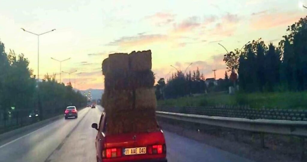 Araba üzerinde saman balyaları taşıdı
